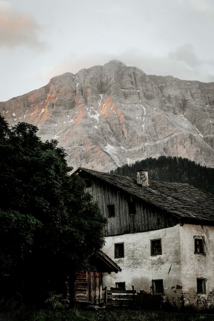 grayscale photo of mountain, white and black wooden house near gray mountain under gray sky during daytime photography HD wallpaper