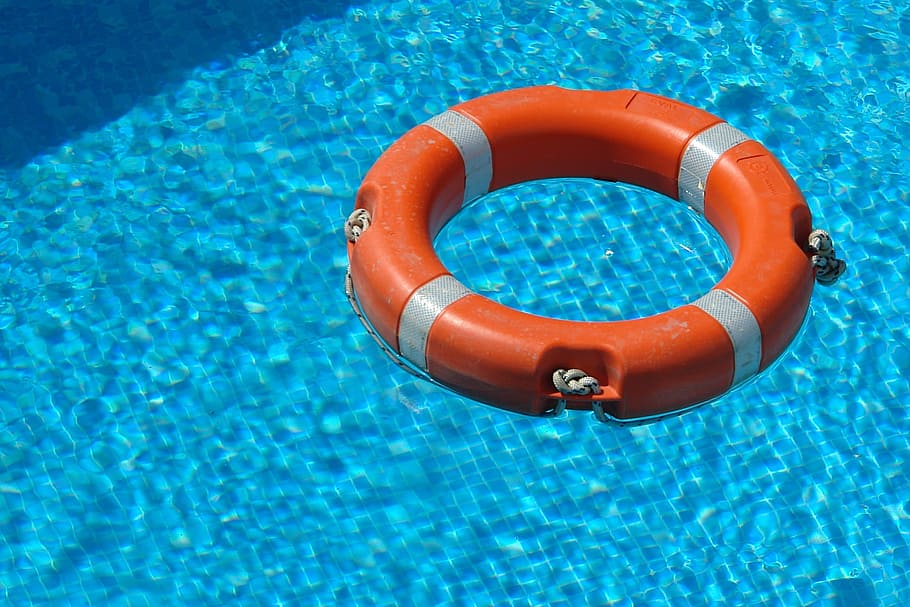 orange survival ring floating on swimming pool, life saver, water