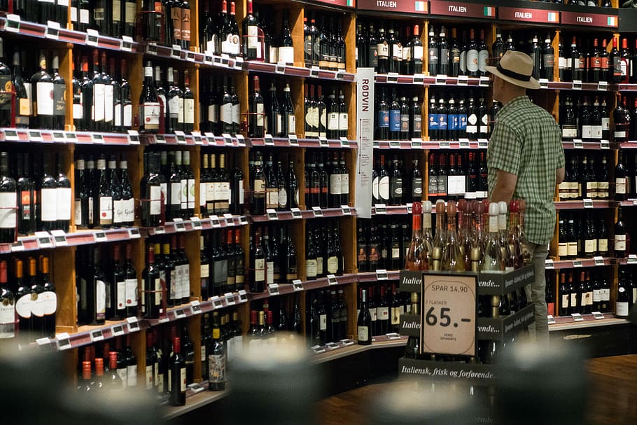 Man choosing wine in a wine store, drink, shelf, indoors, alcohol