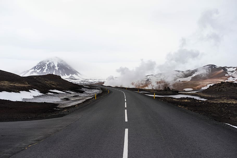 concrete road with snow-capped mountain at distance, gray concrete road near mountain HD wallpaper