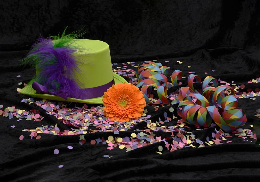 green hat beside orange petaled flower, feather, confetti, streamer HD wallpaper