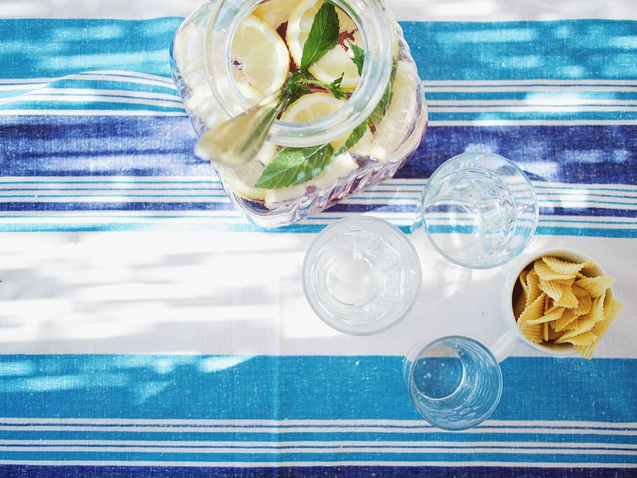 lime juice bottle beside shot glasses on table, sliced lime in glass jar HD wallpaper
