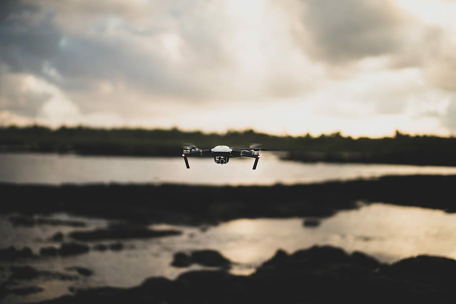 flying white and black drone during daytime, white and black quadcopter flying under white clouds HD wallpaper