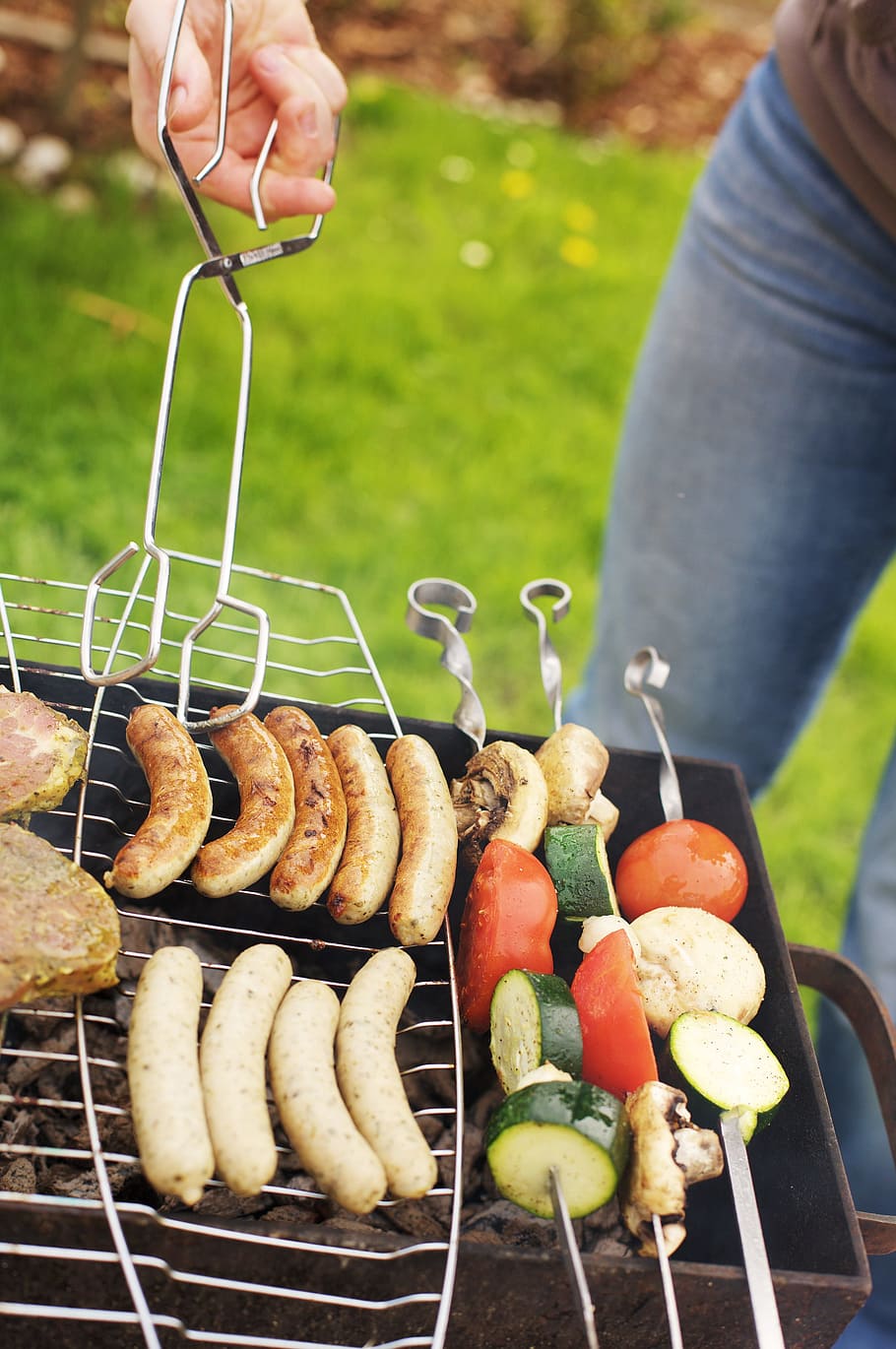 person holding grilling sausage and vegetable skewers outdoor, HD wallpaper