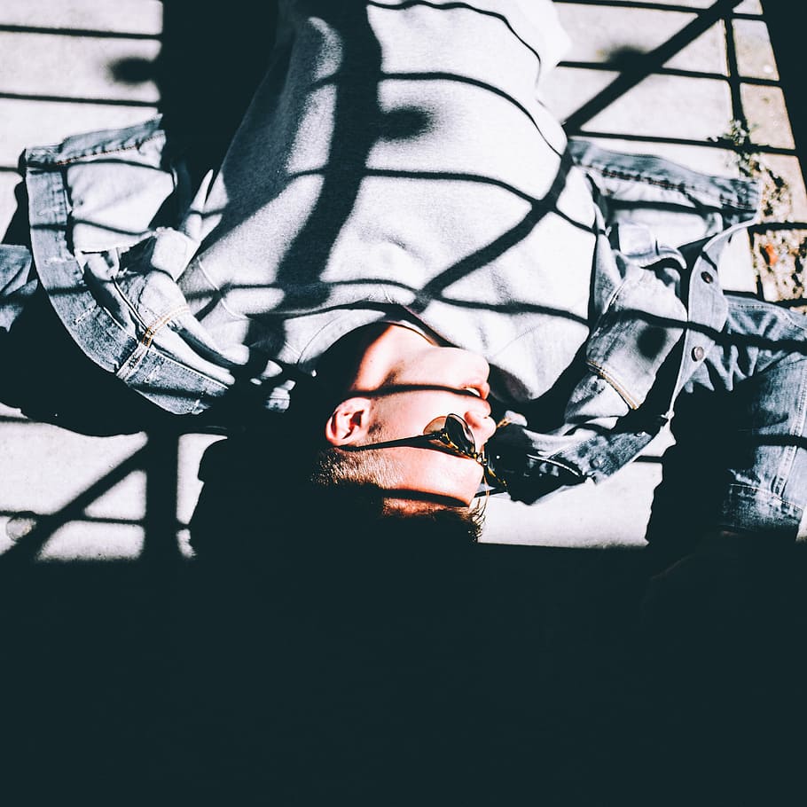 man lying down on floor, man wearing blue denim button-up jacket lying on brown surface HD wallpaper