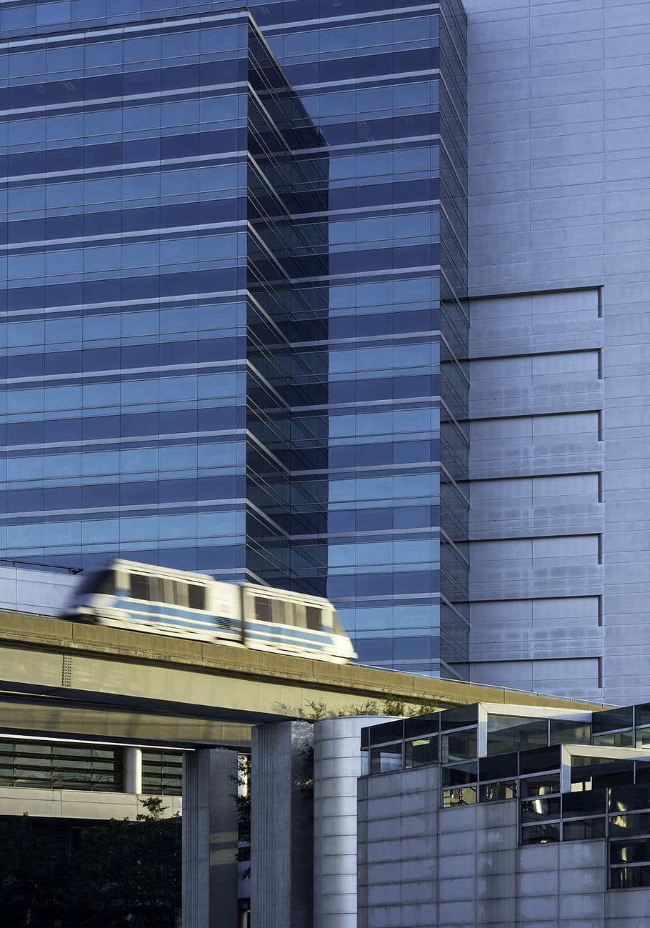 white train during during daytime, gray and blue train near buildings timelapse photography HD wallpaper