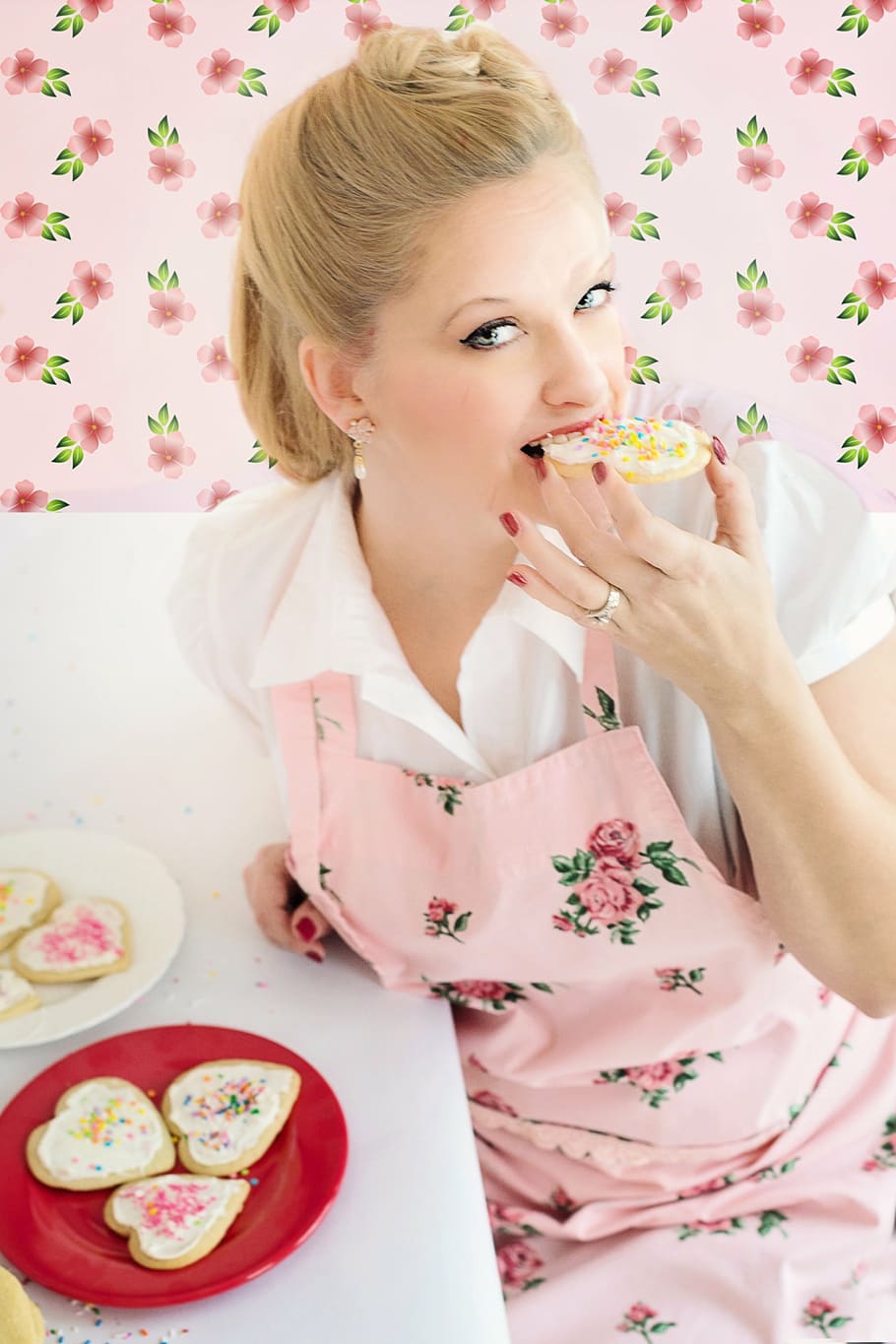 woman in pink floral apron eating cookies, baking, cookie decorating