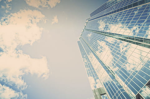 low angle photography of high-rise building, clear glass high-rise building under cloudy sky HD wallpaper