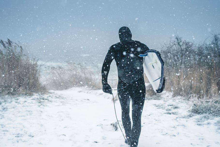 man carrying surfboard walking on snow, man walking on snow, extreme HD wallpaper