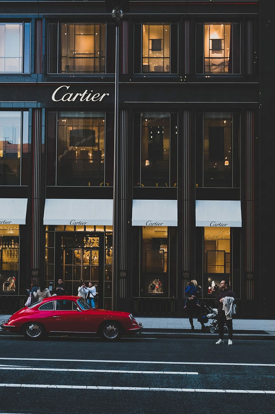 red coupe infront of cartier shop, people outside Cartier building