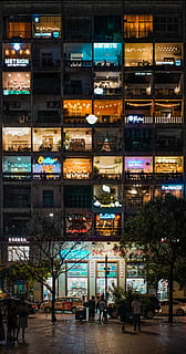 people standing in the street near building, group of people on street in front of lighted building HD wallpaper