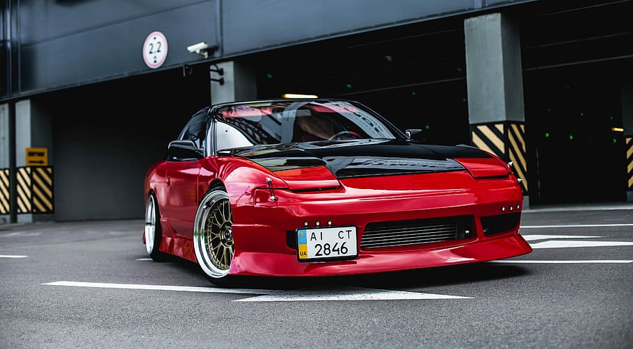 red coupe on gray concrete ground, red vehicle on road near gray post HD wallpaper