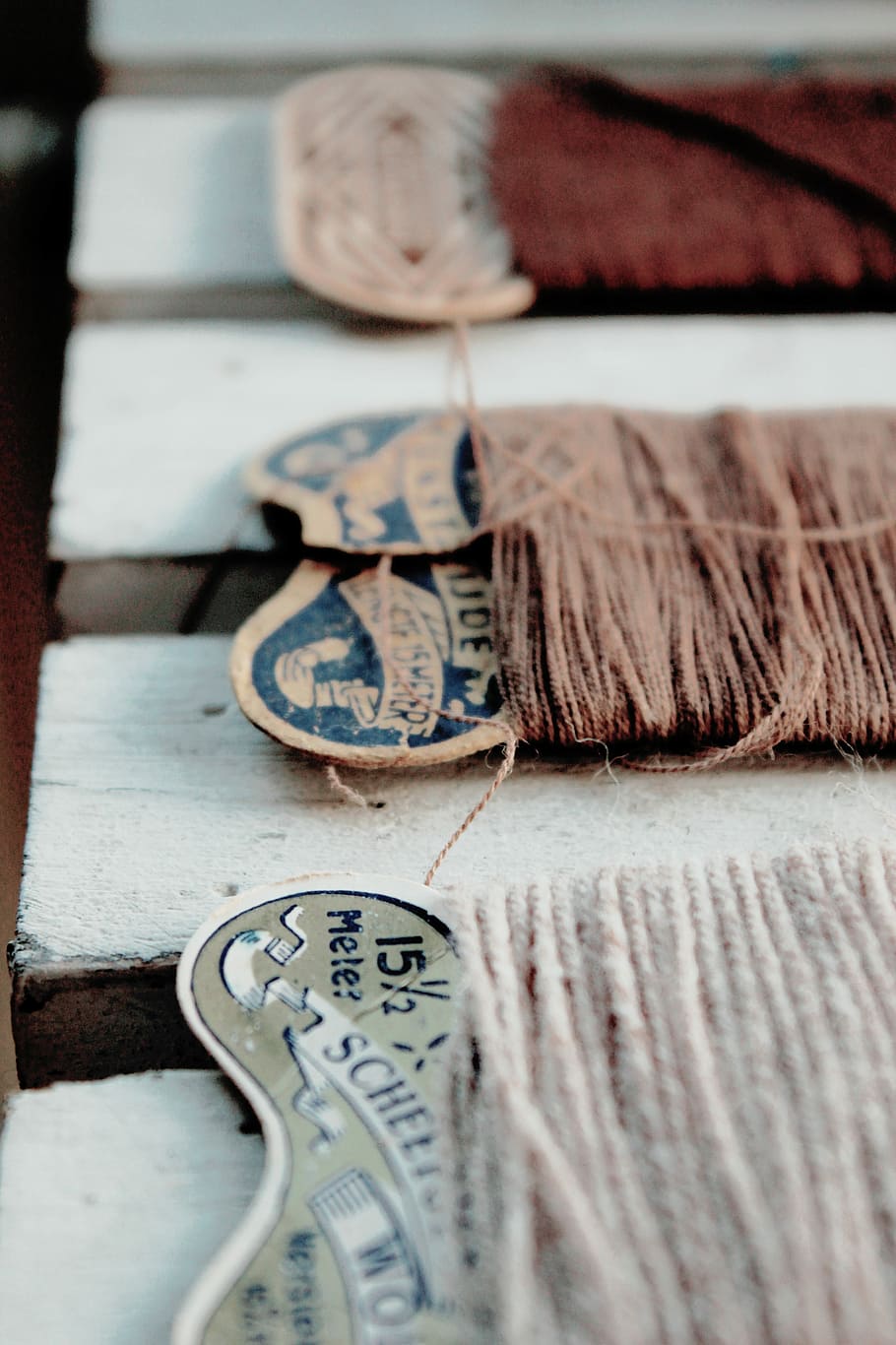 close-up photography of brown thread, three threads on white wood HD wallpaper