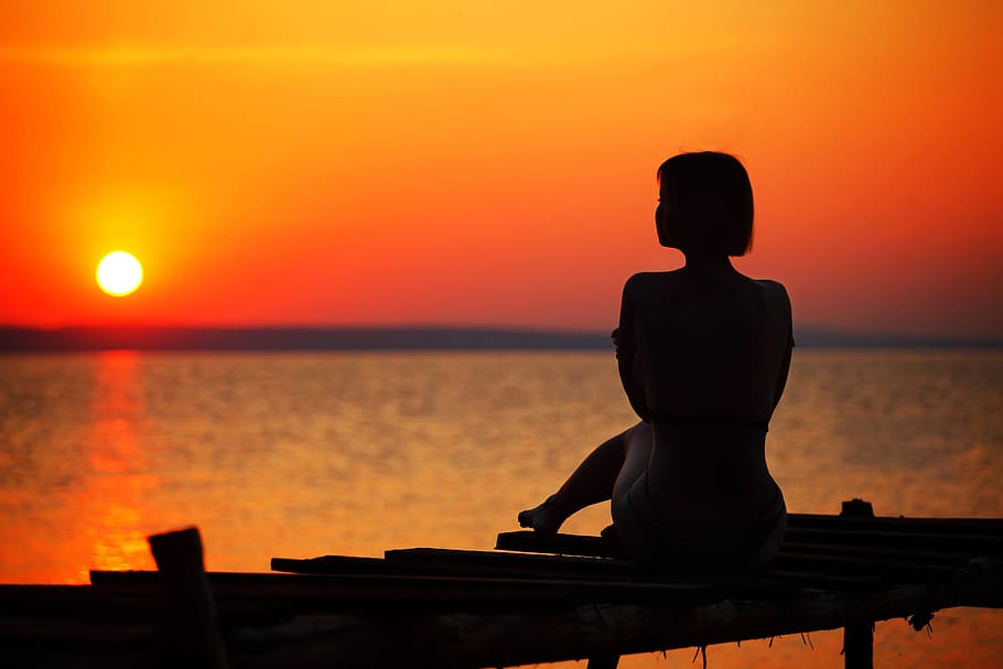 Silhouette of Woman Sitting on Dock during Sunset, beach, dawn