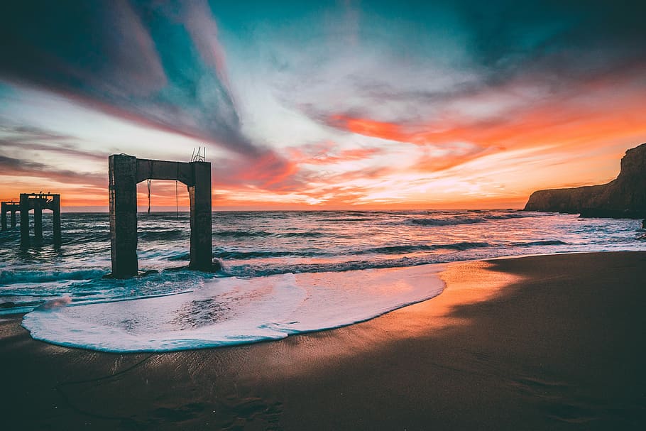 sea with stage, gray concrete towers on ocean at sunset, beach HD wallpaper
