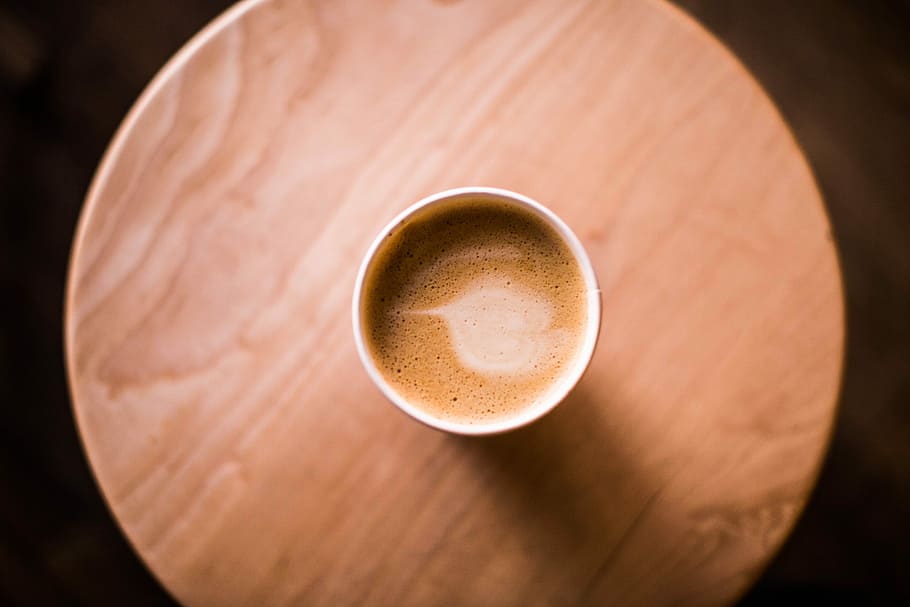 top view photo of brown ceramic mug with coffee, coffee filled cup on round brown table HD wallpaper