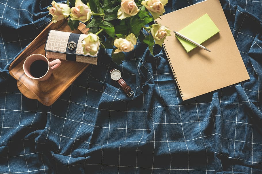 white rose flower bouquet beside brown note, round white analog watch with brown leather band and rectangular brown wooden serving tray on blue and white blanket close-up photo, pink roses near notebook and pen HD wallpaper