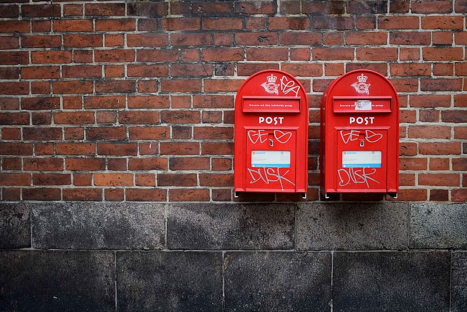 photo of two red post boxes mounted in brown concrete wall, photo of mounted red mail boxes