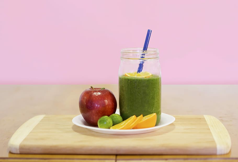 green liquid on drinking glass with assorted fruits on the plate HD wallpaper