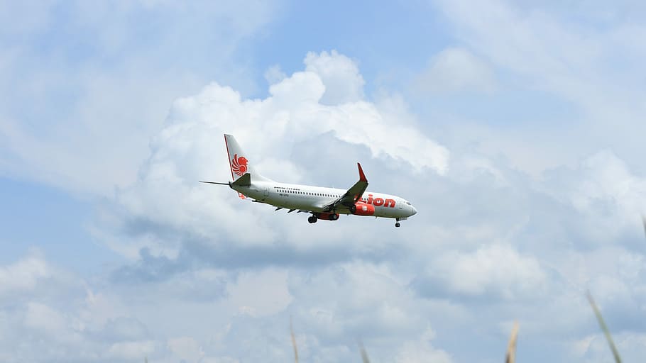 white and red passenger plane under white clouds at daytime HD wallpaper