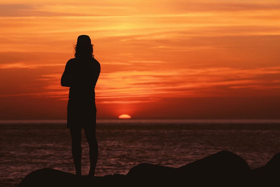 silhouette of man standing near body of water, silhouette photography of man standing near body of water during golden hour HD wallpaper