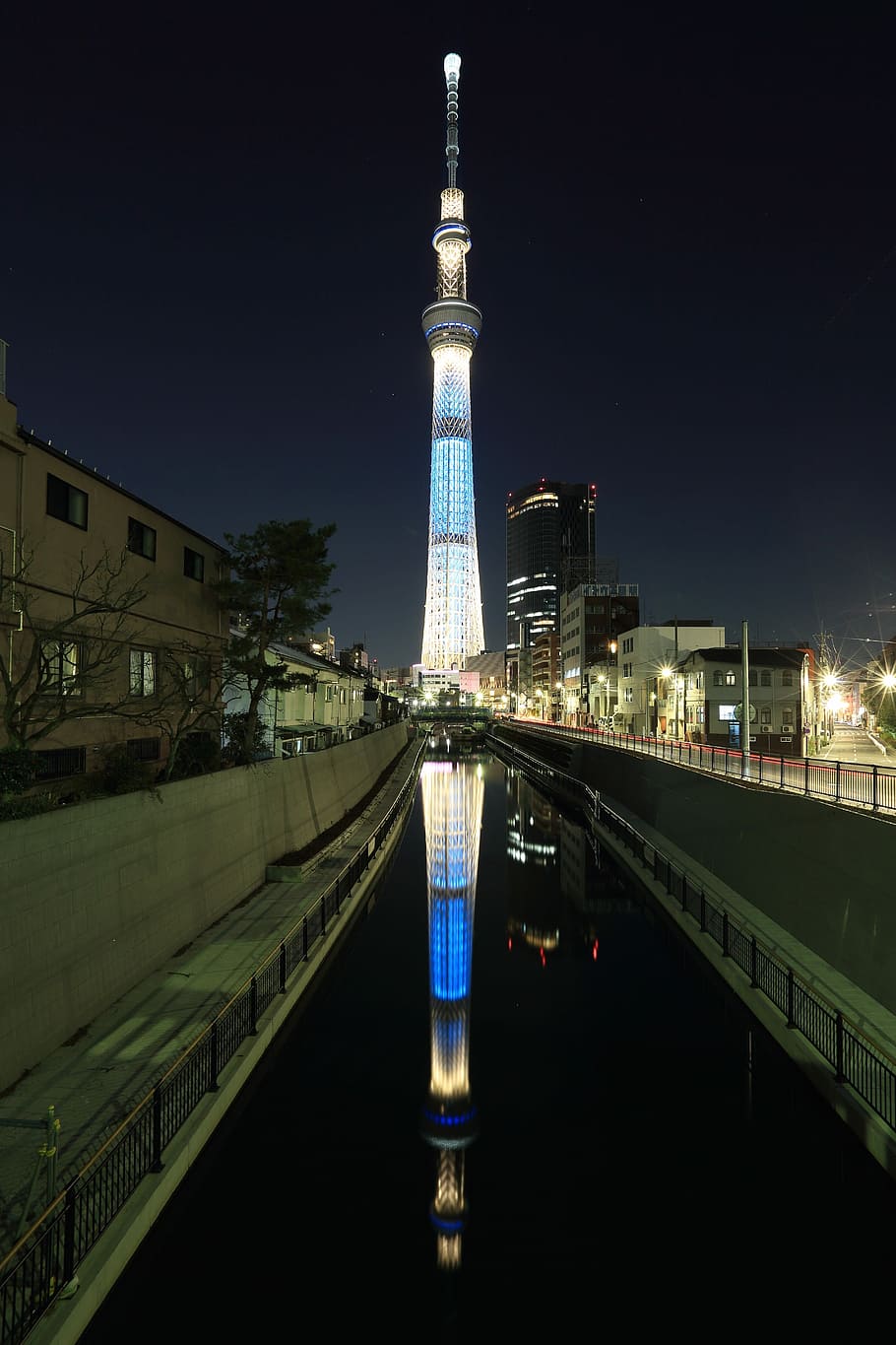architectural photo of gray concrete tower in city skyline during nighttime HD wallpaper
