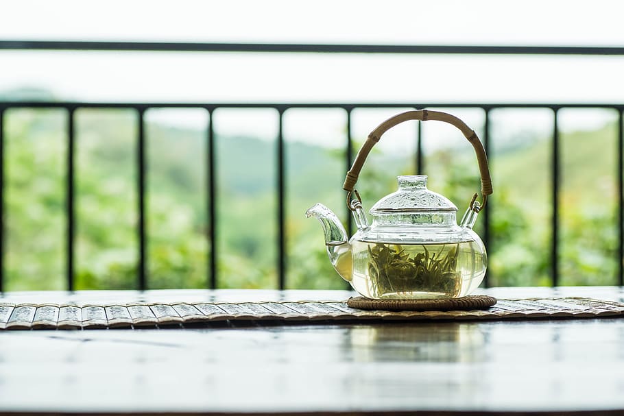 clear glass teapot with green liquid on round brown tablet cloth HD wallpaper