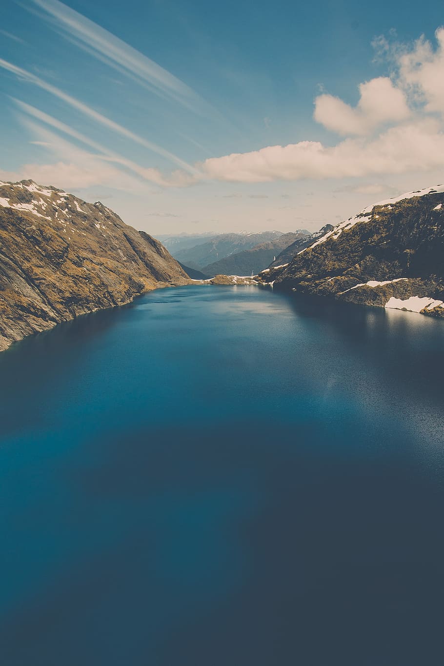 river between mountains under clear sky, body of water and snow-covered mountains during daytime HD wallpaper