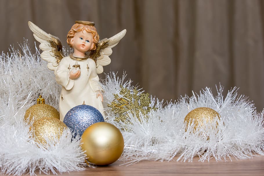 cherub figurine beside assorted-color baubles, christmas presents