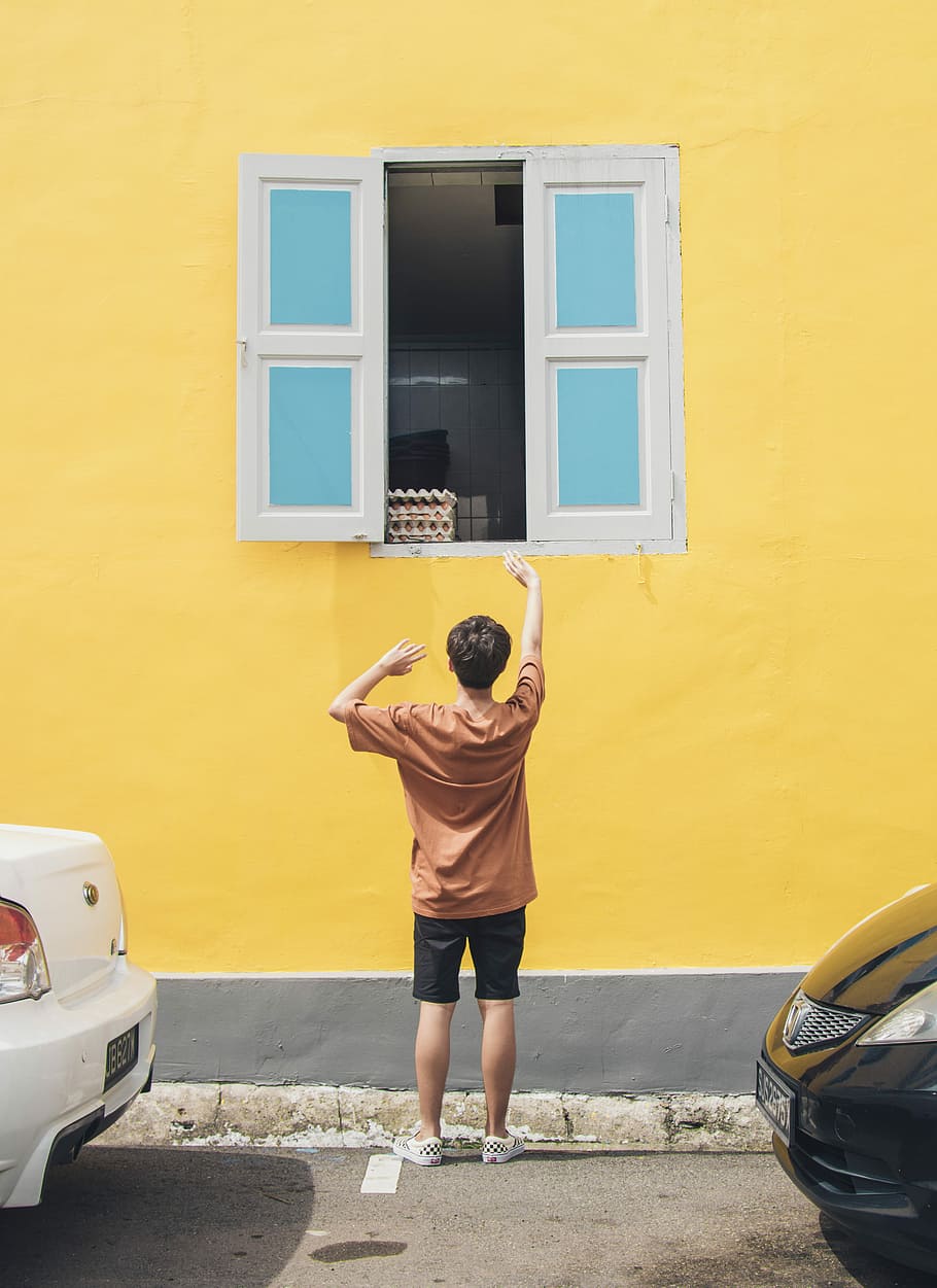 boy in front of window raising hand during daytime, person standing in front of window during daytime HD wallpaper