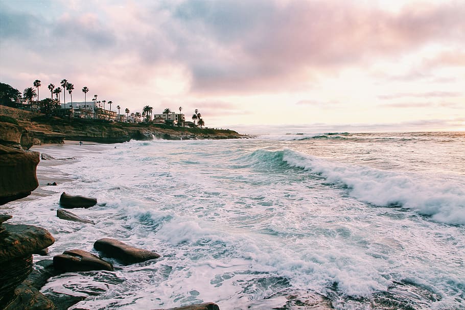 sea waves crashing on shore during golden hour, sea wave with establishment building near the shore HD wallpaper