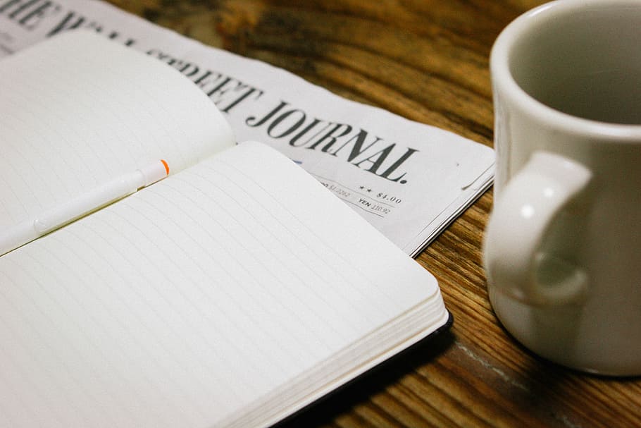 white ceramic mug near opened white notebook on brown wooden desk, white notebook beside white mug HD wallpaper