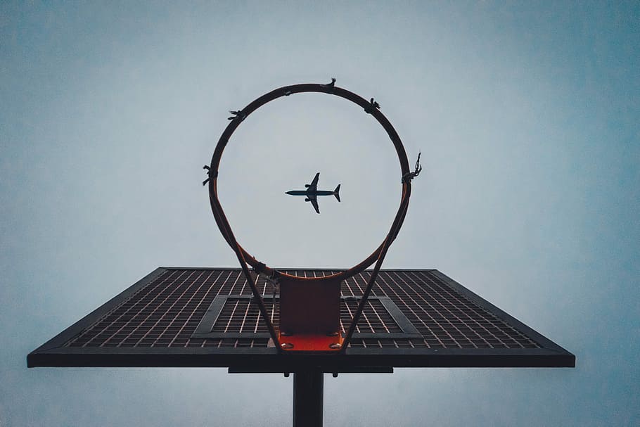 Lucky Shot, force perspective photography of airplane passing above black metal basketball hoop HD wallpaper
