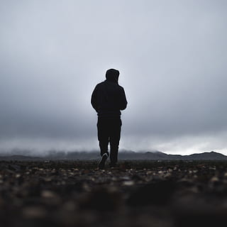 silhouette of person wearing black hoodie under cloudy sky HD wallpaper