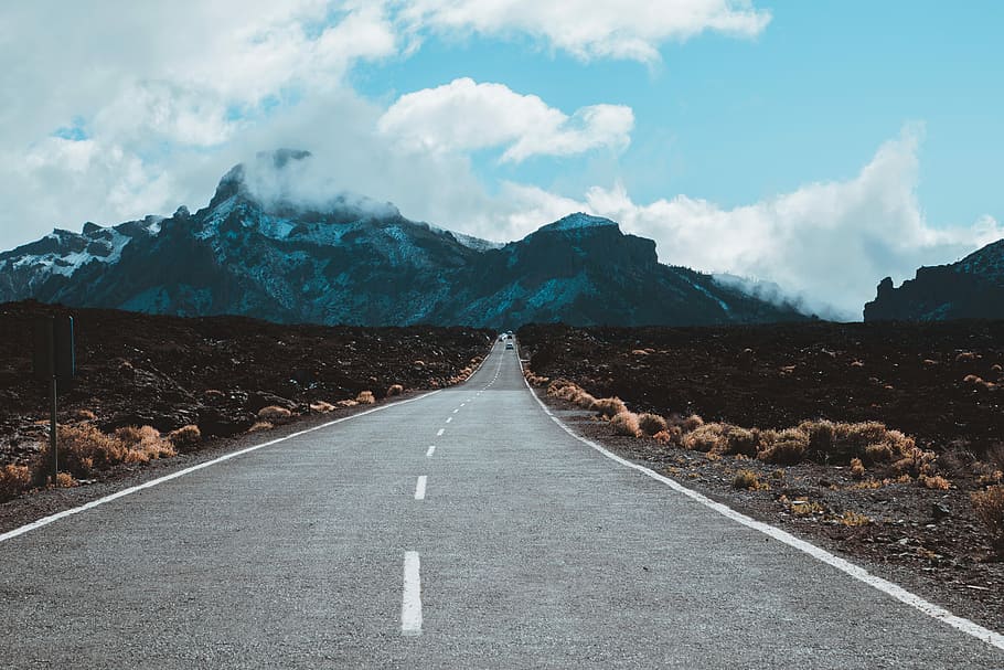 straight road leading to mountain, gray concrete road towards mountain at daytime HD wallpaper