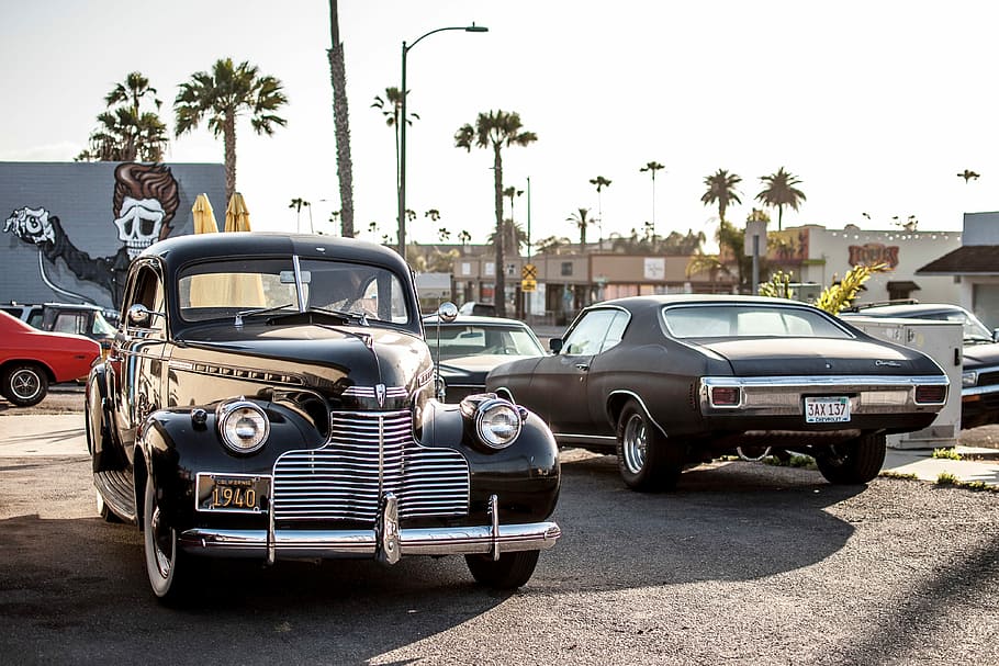 black vintage car beside brown classic coupe under clear blue sky during daytime HD wallpaper