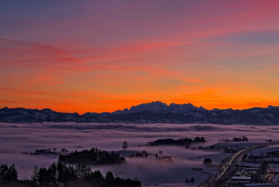 mountain silhouette during sunset, aerial photography of city near building HD wallpaper