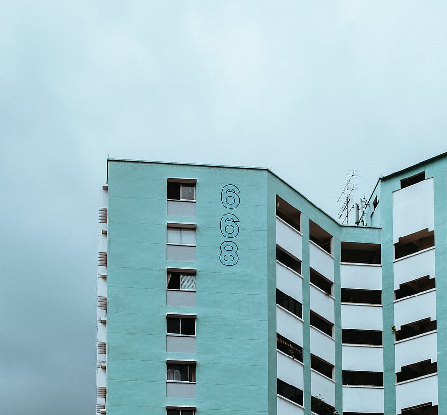 blue and white concrete building, teal and white 668 concrete high-rise building under cloudy sky during daytime HD wallpaper