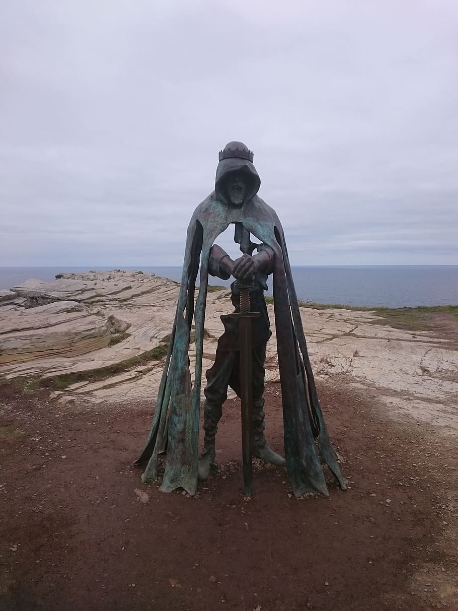 man in robe holding sword statue near cliff, king arthur, knight