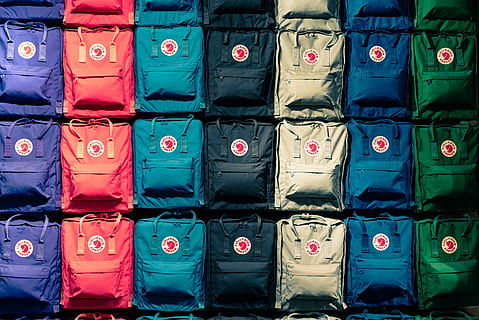 person showing assorted-color bags, assorted-color backpack lot HD wallpaper