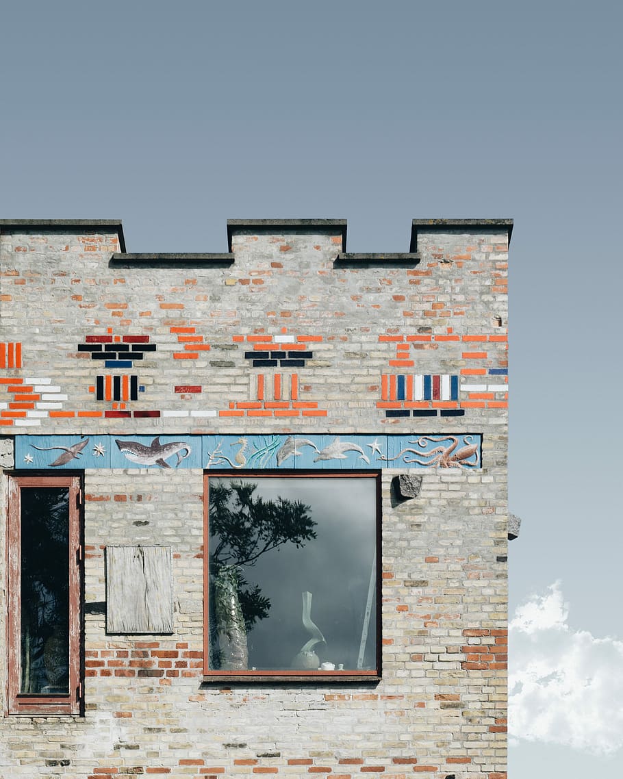 white building with fish print, gray and orange brick building under gray sky during daytime photogrpahy HD wallpaper