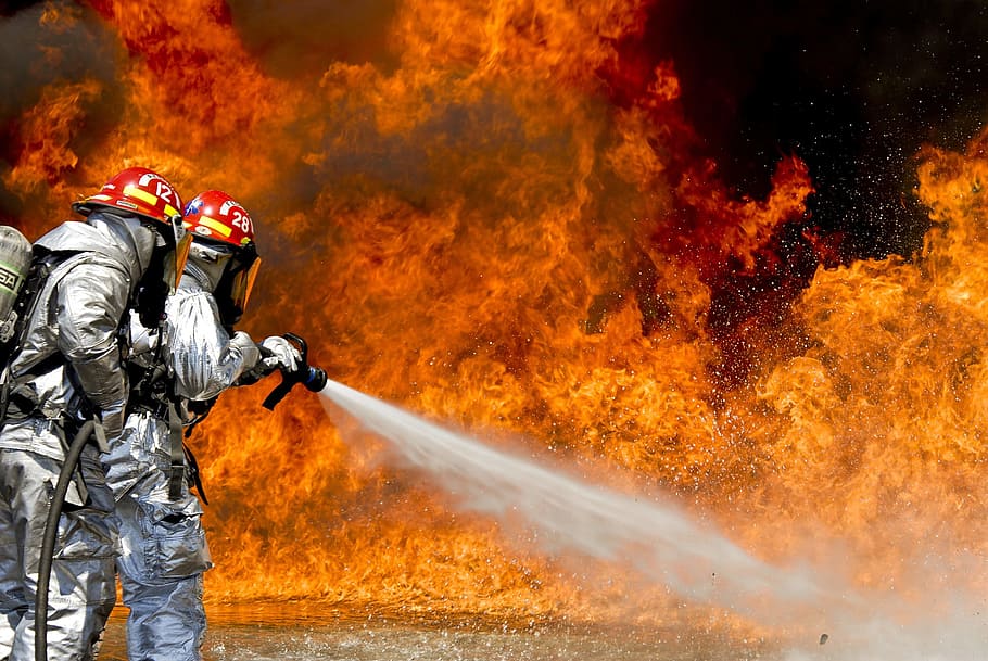 firefighters wearing silver suits spraying foam on fire, flames HD wallpaper
