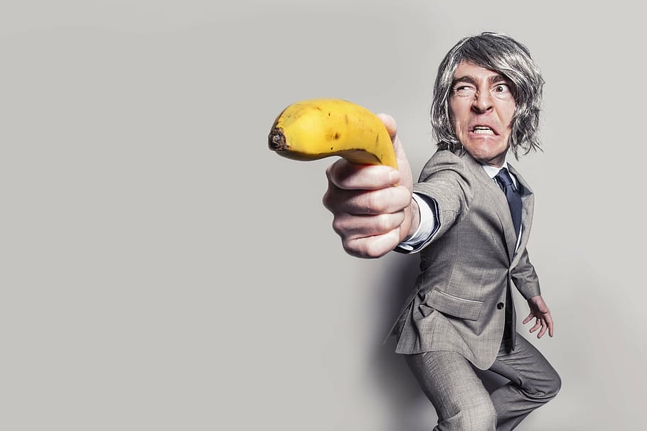 person wearing suit holding banana near wall, business man, male