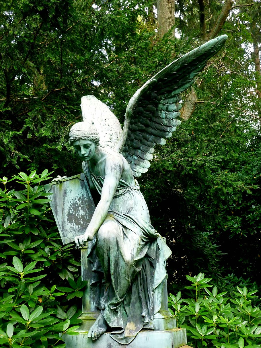 statue of angel holding rectangular board sitting on brick, sculpture
