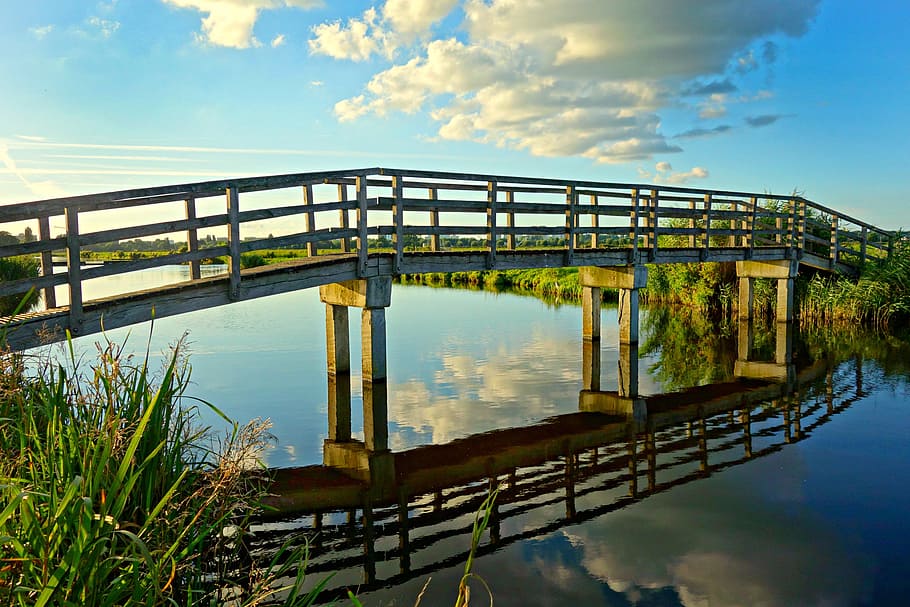 white clouds and clear blue sky reflection on river under gray and brown bridge HD wallpaper