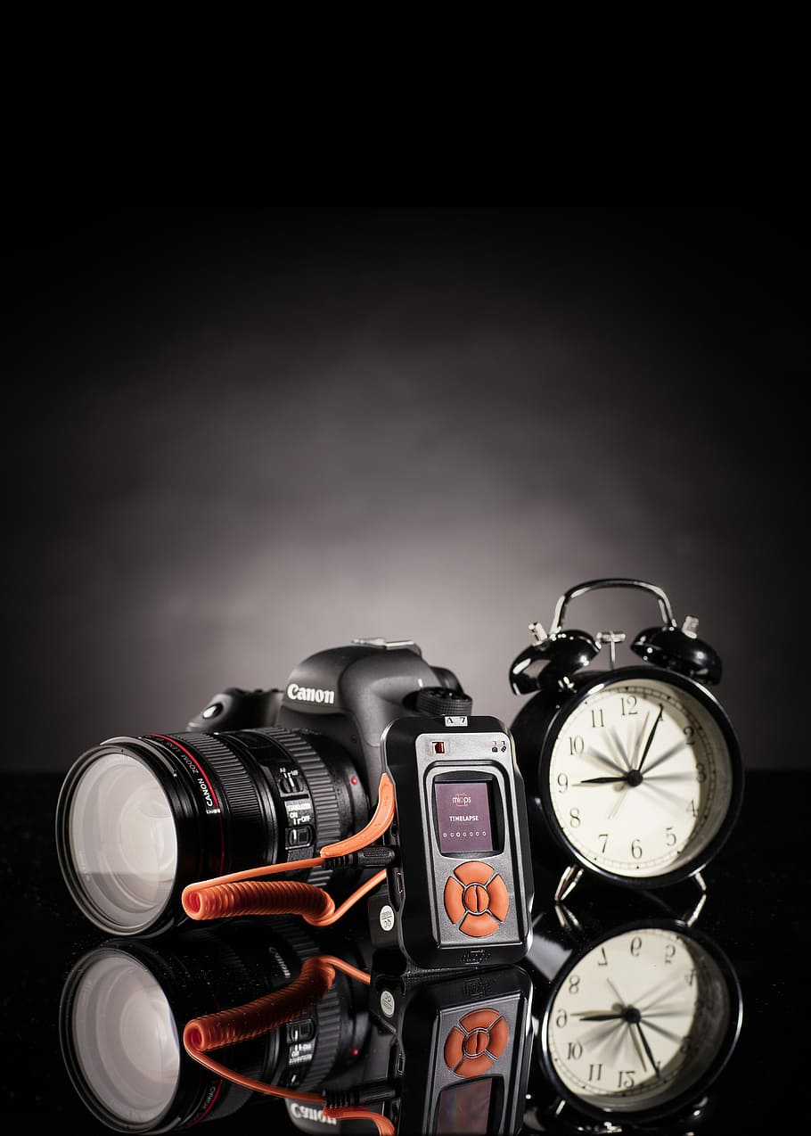 photo of Canon DSLR camera beside black twin bell alarm clock, black Canon EOS DSLR camera near black bell alarm clock HD wallpaper