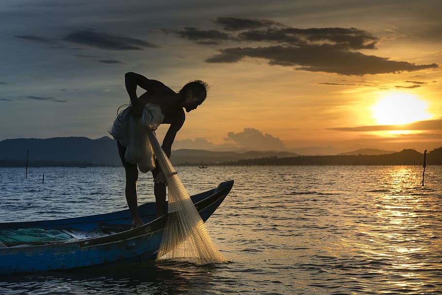 person riding row boat while holding fishing net, the fishermen