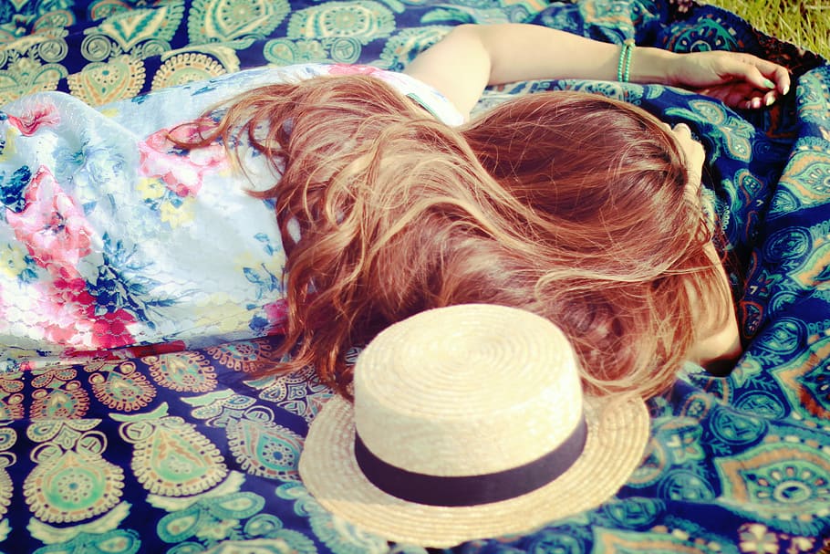 female in blue floral shirt laying on blue floral picnic mat with sunhat HD wallpaper