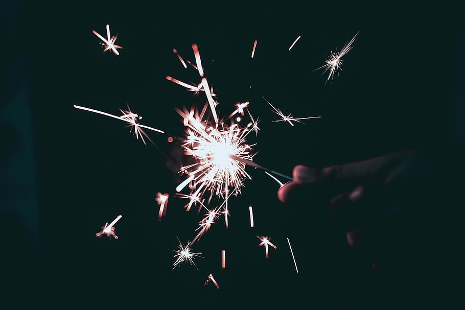 person holding sparkling light, person holding sparkle, sparks HD wallpaper