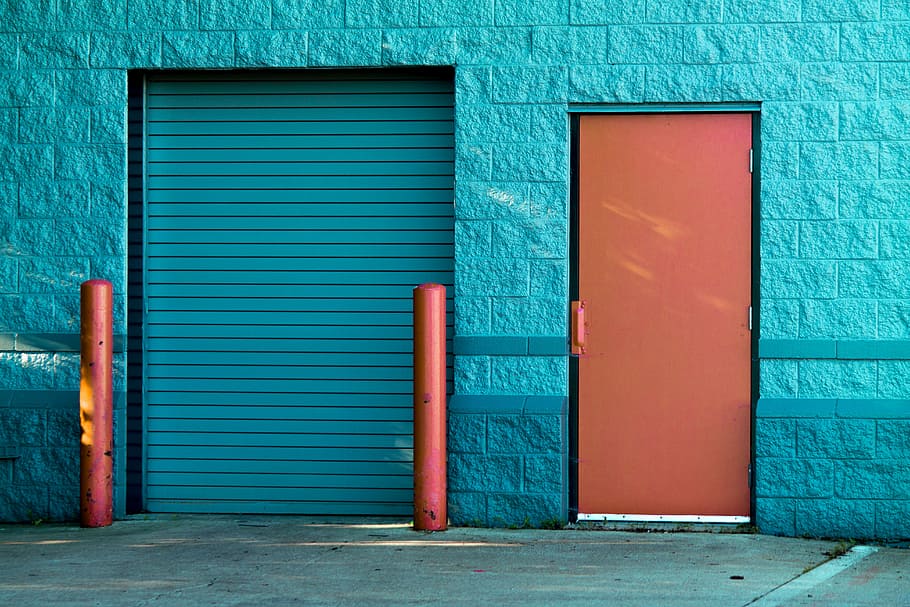 closed door and gate, blue concrete building with blue and orange doors at daytime HD wallpaper